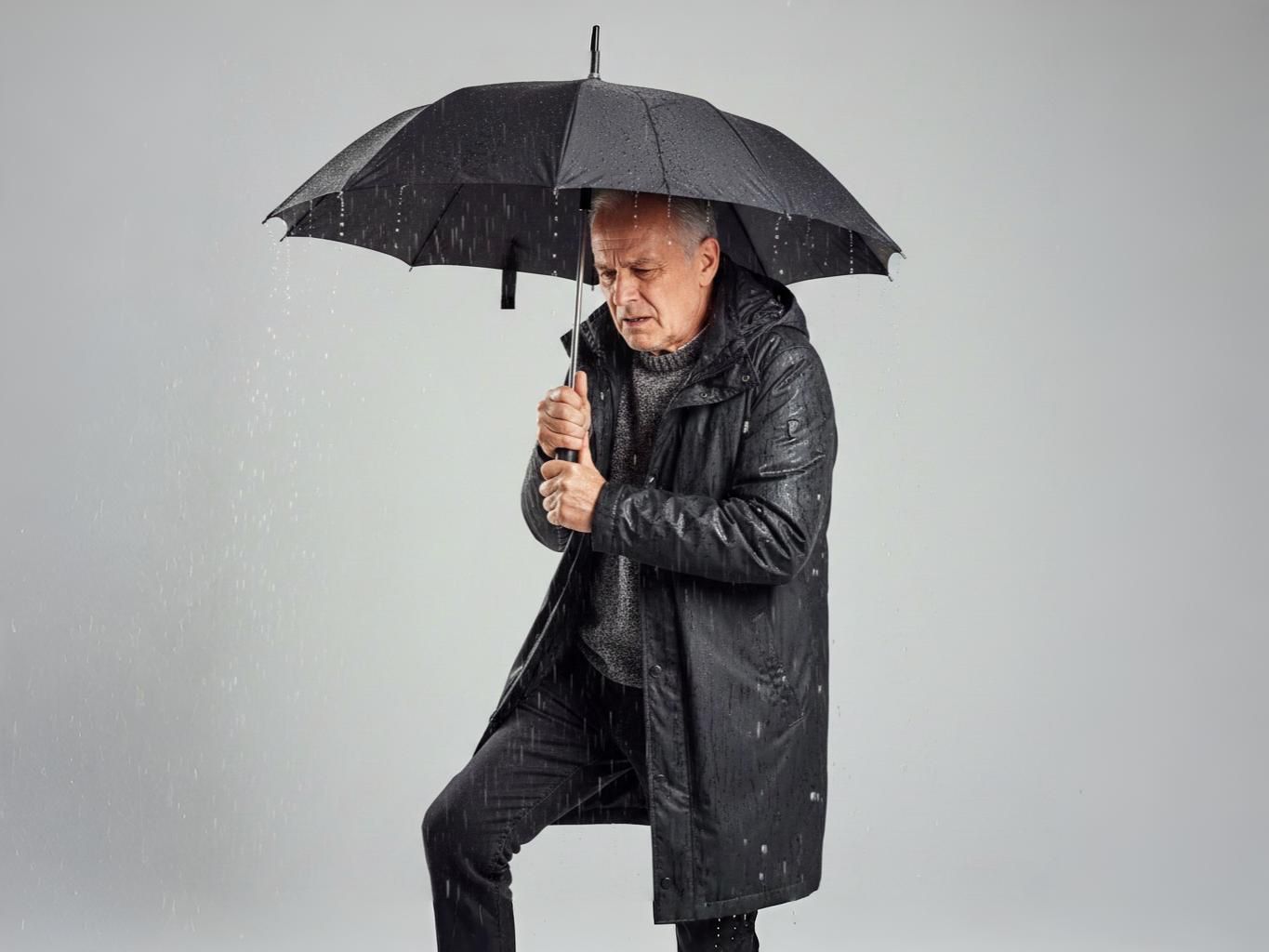 Homme avec parapluie sous la pluie - Douleurs articulaires et humidité